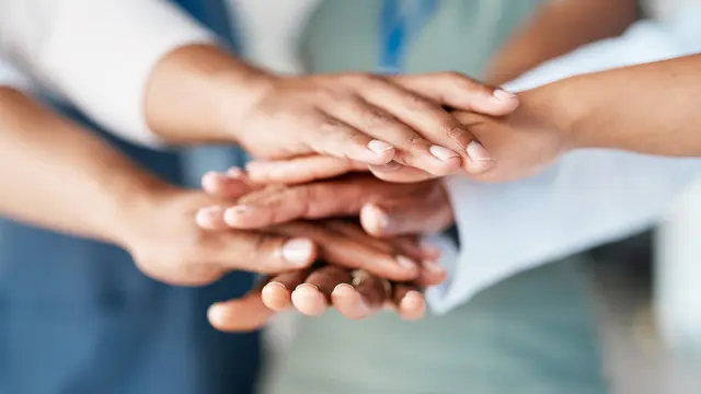 Hands stacked together, symbolizing the shared commitment to the Bosch Code of Conduct, teamwork, and our values.