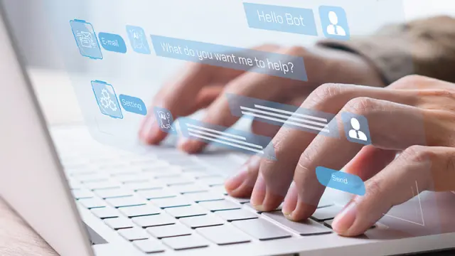 A person types on a laptop, interacting with a futuristic, transparent chatbot interface that floats above the keyboard.